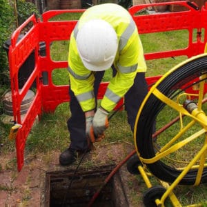 Workman unblocking a sewer