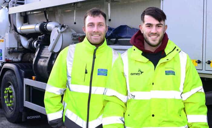 Two Severn Trent workers in day glow high visibility jackets, smiling